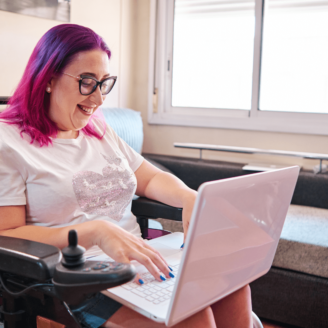 Participant in a wheelchair working on a laptop at home